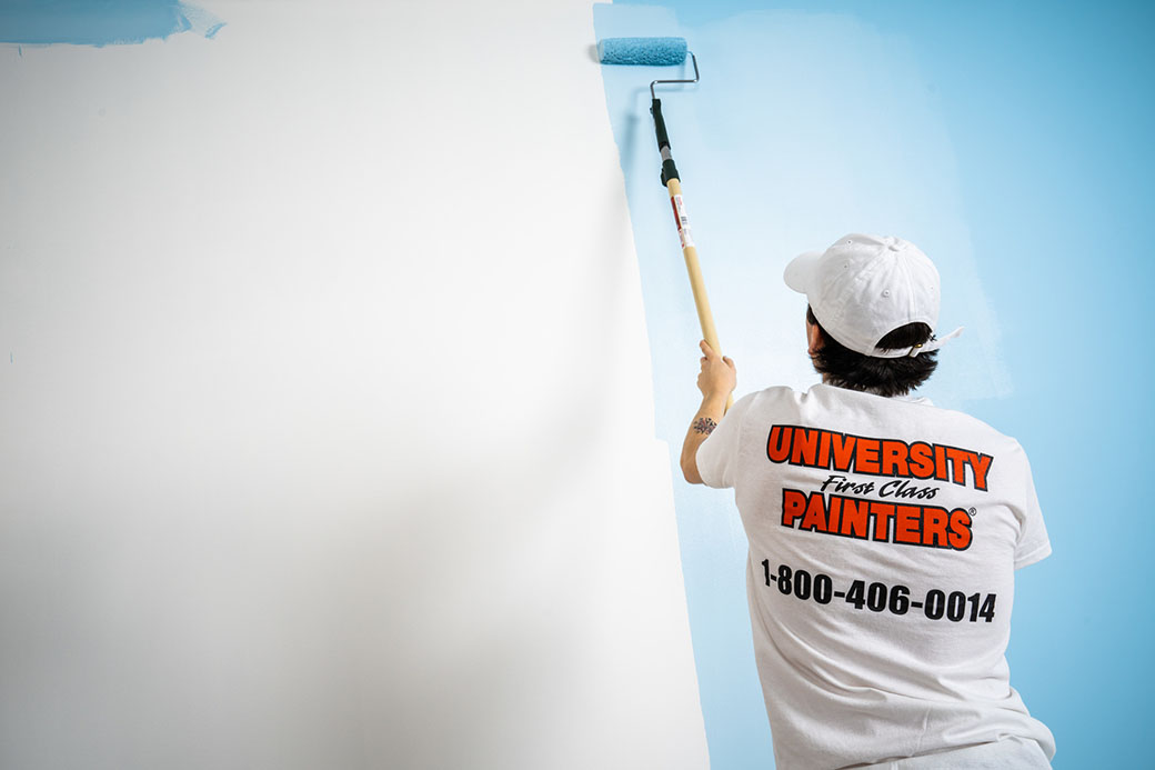 painter with UFCP logo shirt painting a white wall