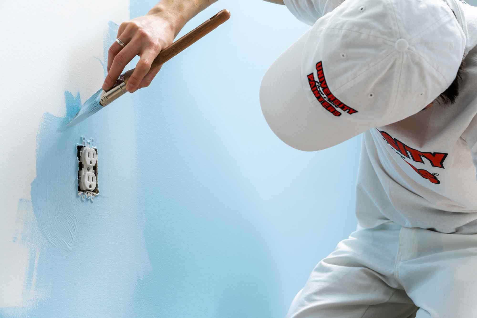 close up of painting contractor in Edmonton working around an outlet